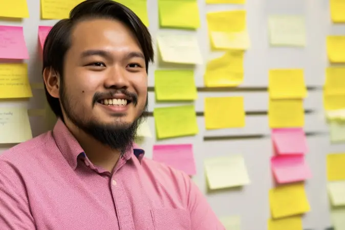 Man smiling in front of a outline board